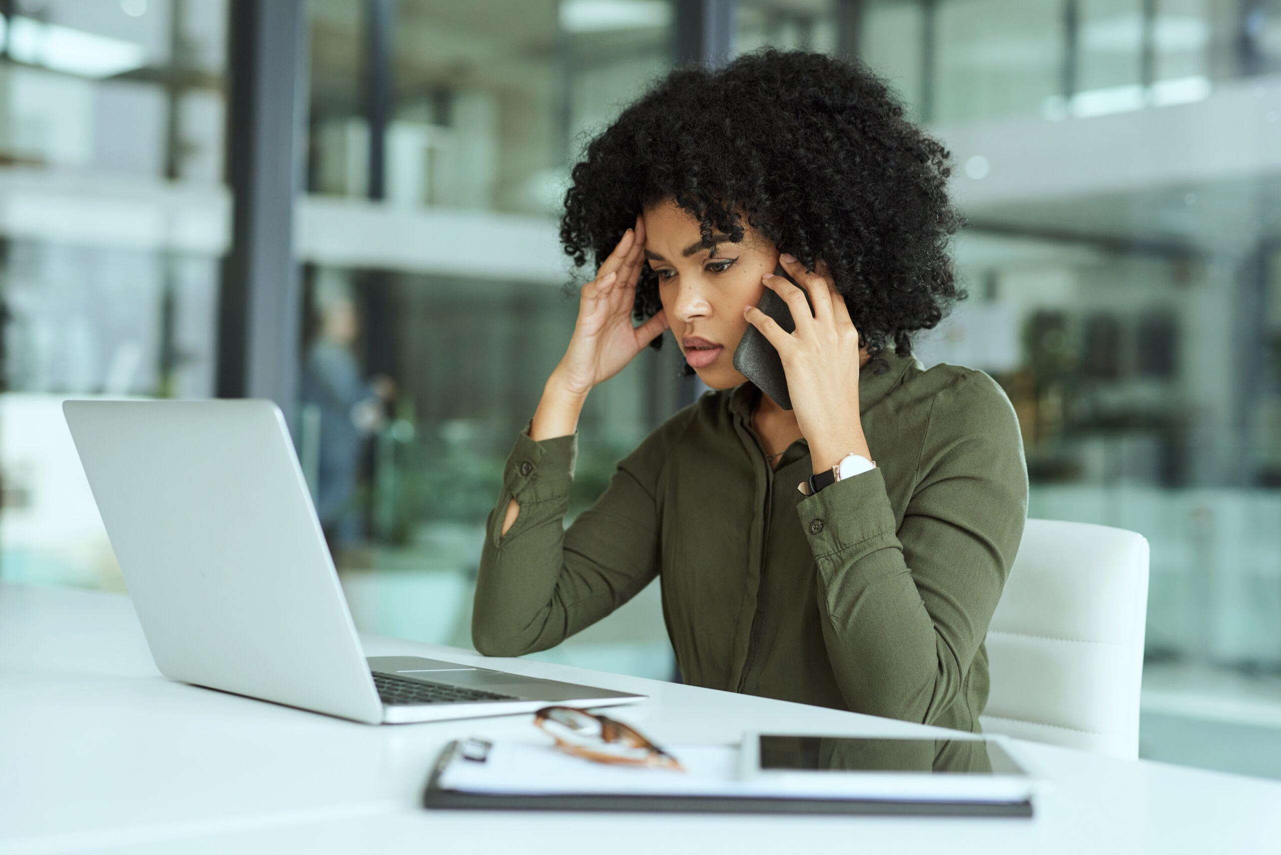 woman looking stressed sitting at a desk looking at her computer while trying to figure out personal injury claims with pain and suffering