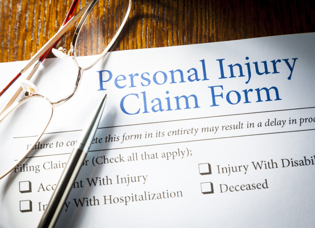 Personal Injury Claim form with pen and glasses on a table at a law firm