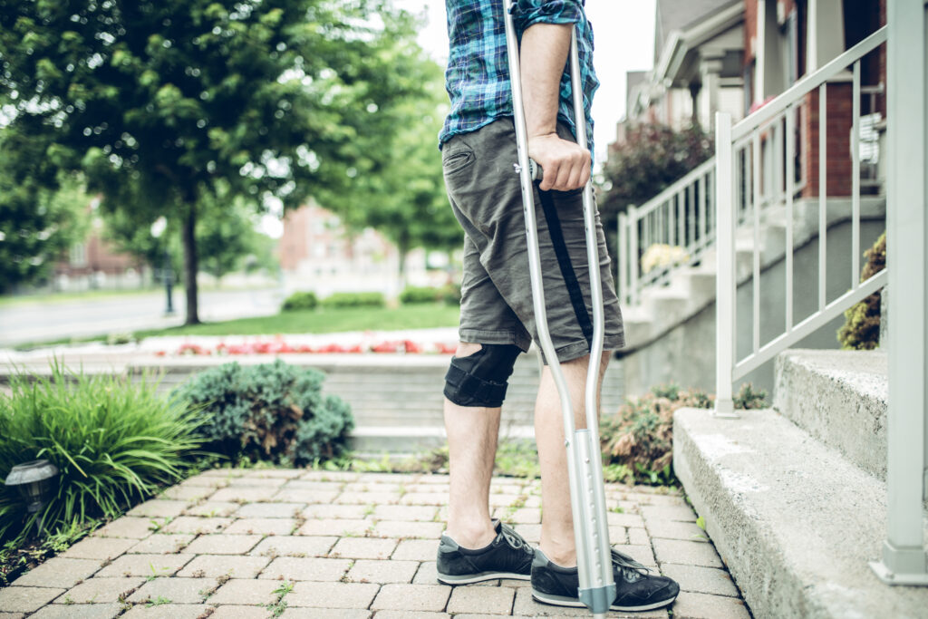 man using crutch after having knee sprain accident due to someone elses negligence in a personal injury accident in lenior
