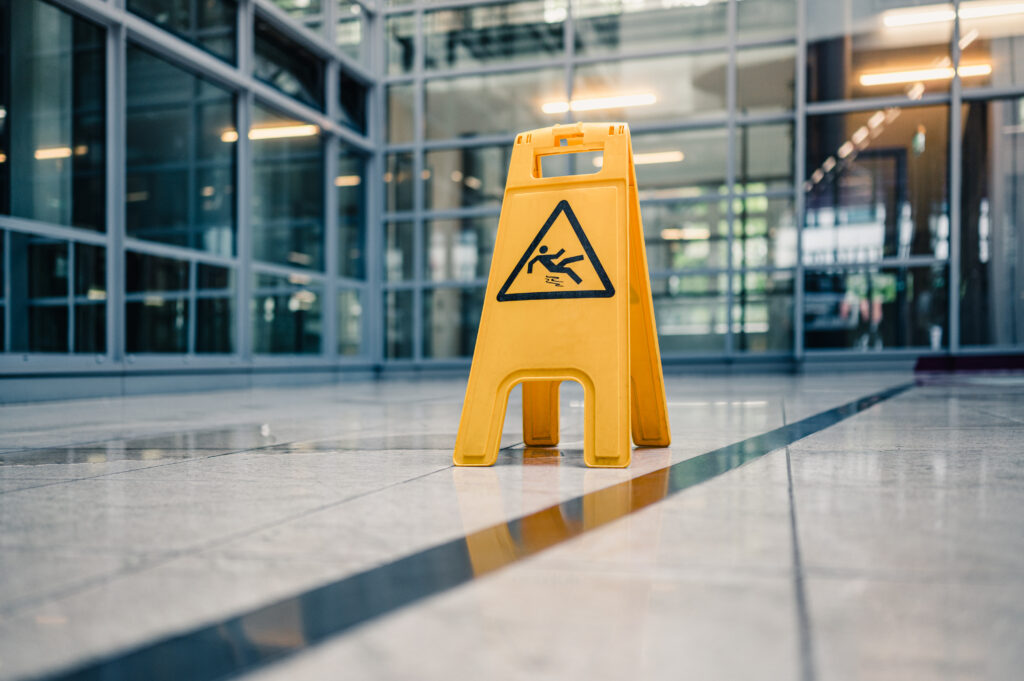 Yellow sign on floor that alerts for wet floor. premises liability slip and fall theme