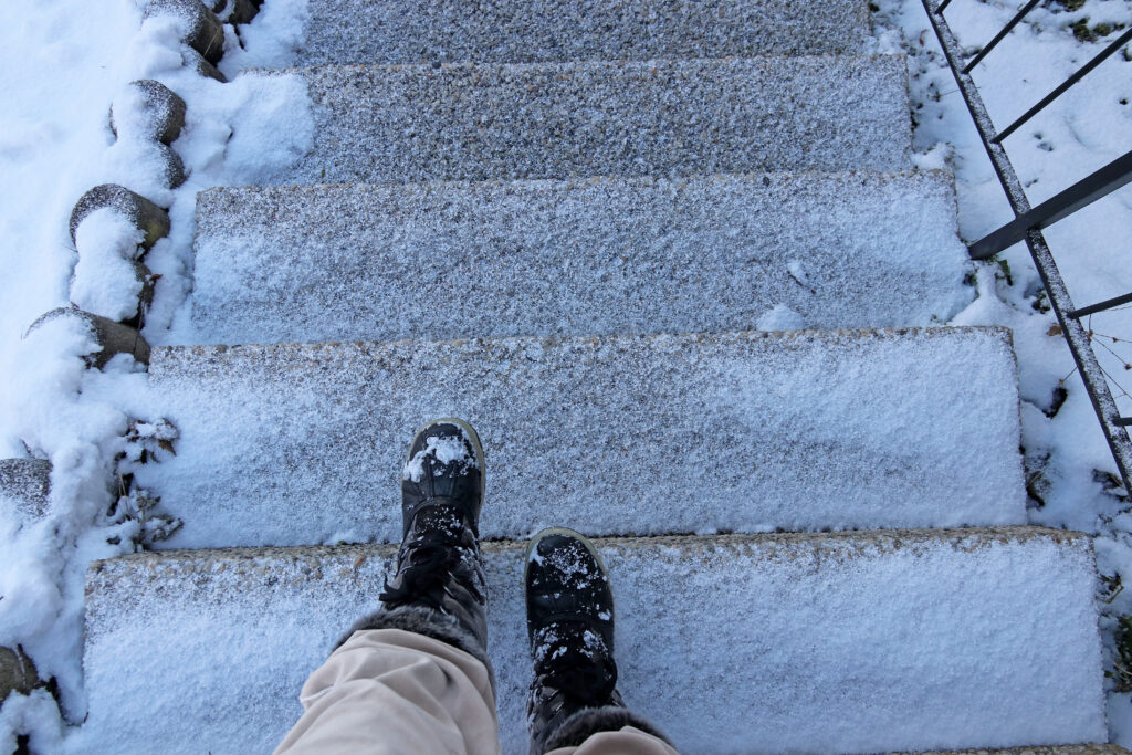 Danger of accident on snow-covered slippery steps of stairs in winter, slip and fall lawyer