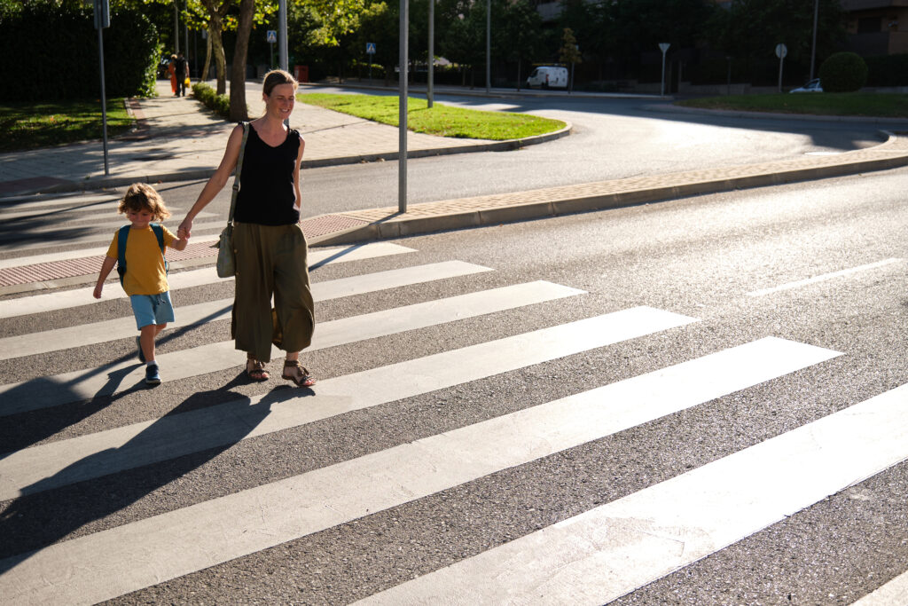 Mother and her son crossing road on way to school