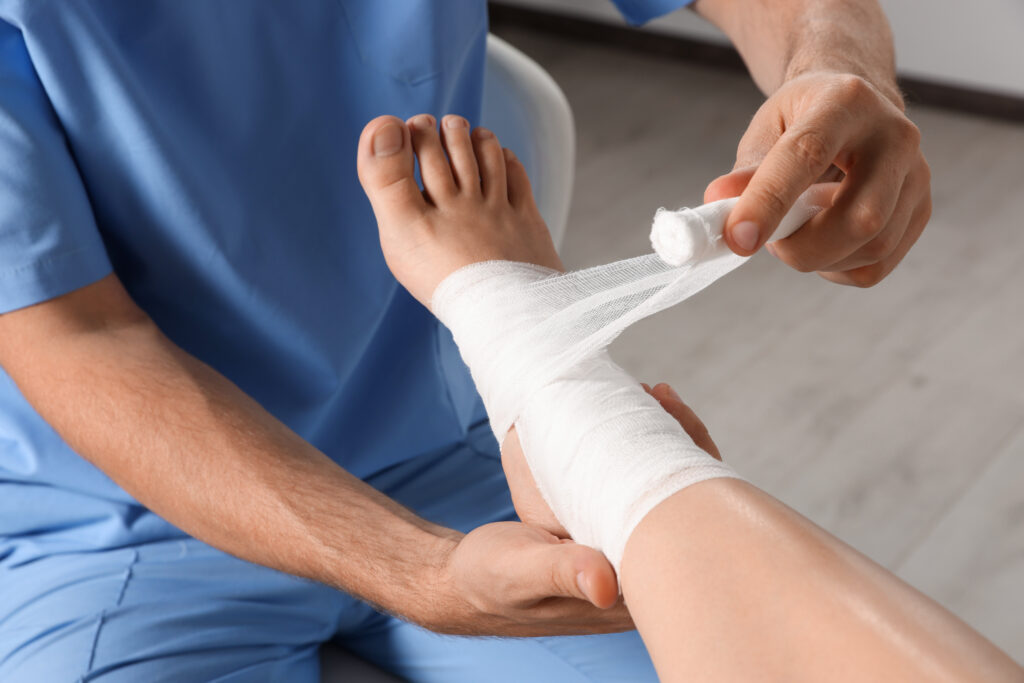 Doctor applying bandage onto patient's foot in hospital, closeup, slip and fall injury in hickory