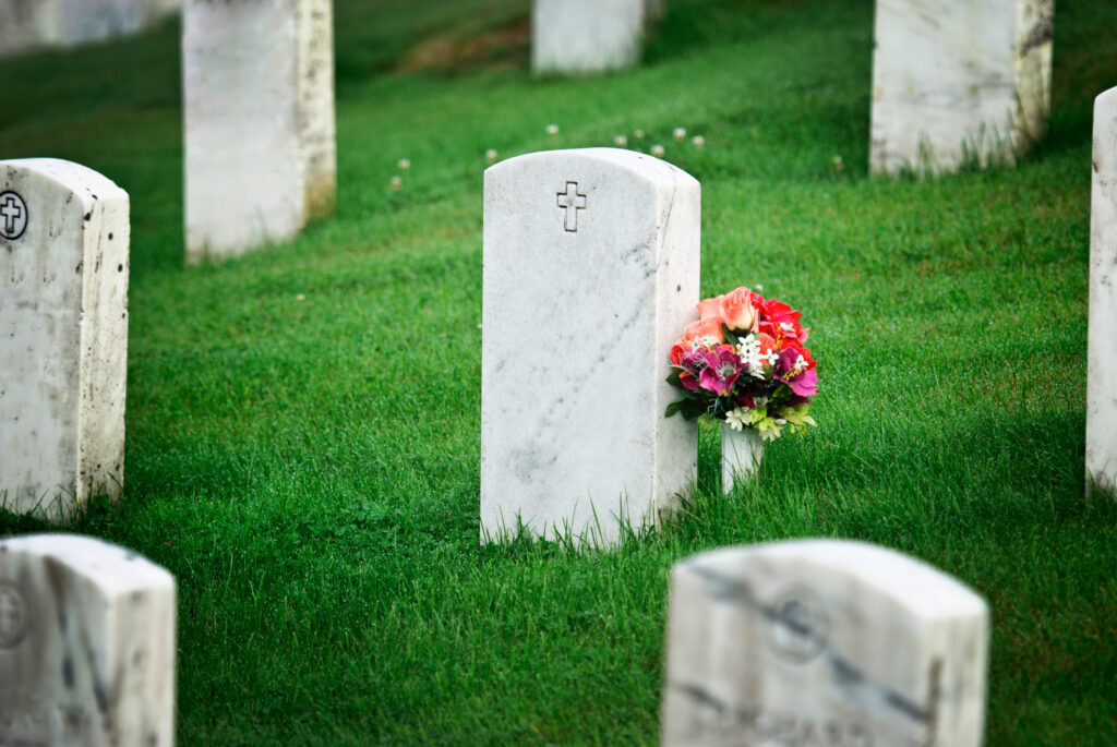 tombstone with flowers in graveyard after a wrongful death incident