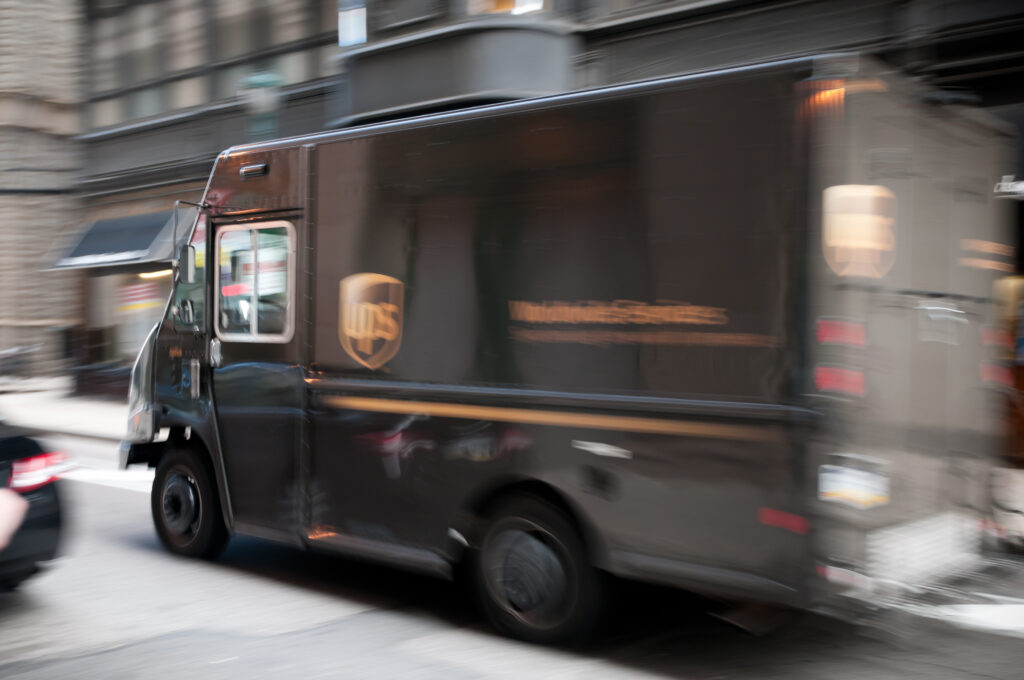 A brown United Parcel Service (UPS) truck driving through downtown Charlotte