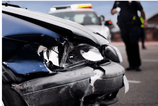 un coche averiado con un policía al fondo